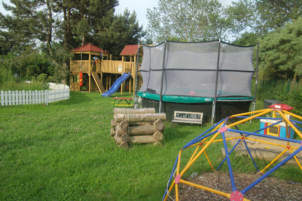 Ostansicht des Kinderspielplatzes mit Trampolin und Kletterpilz